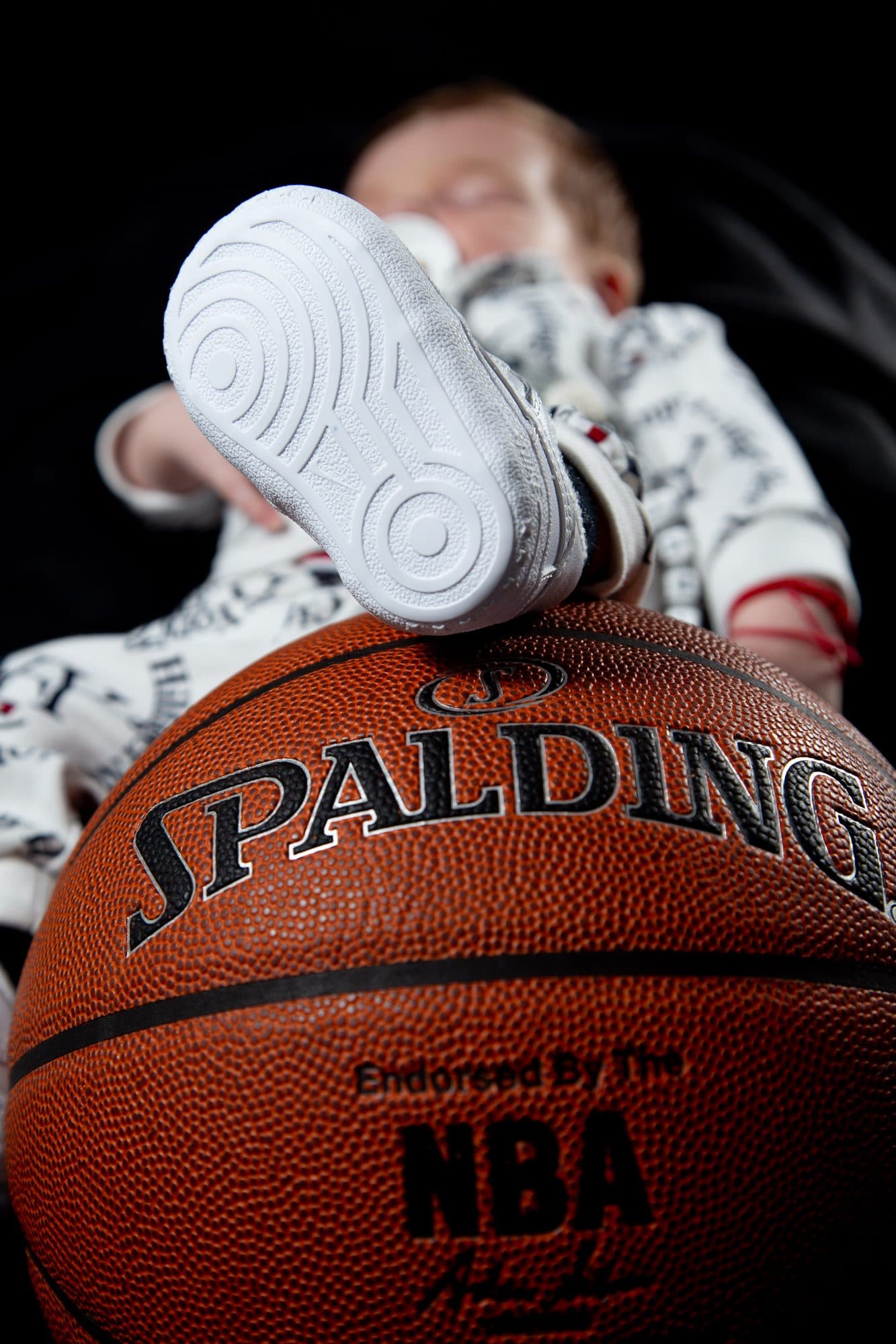 Baby liegt auf Basketball, verspieltes Detailbild