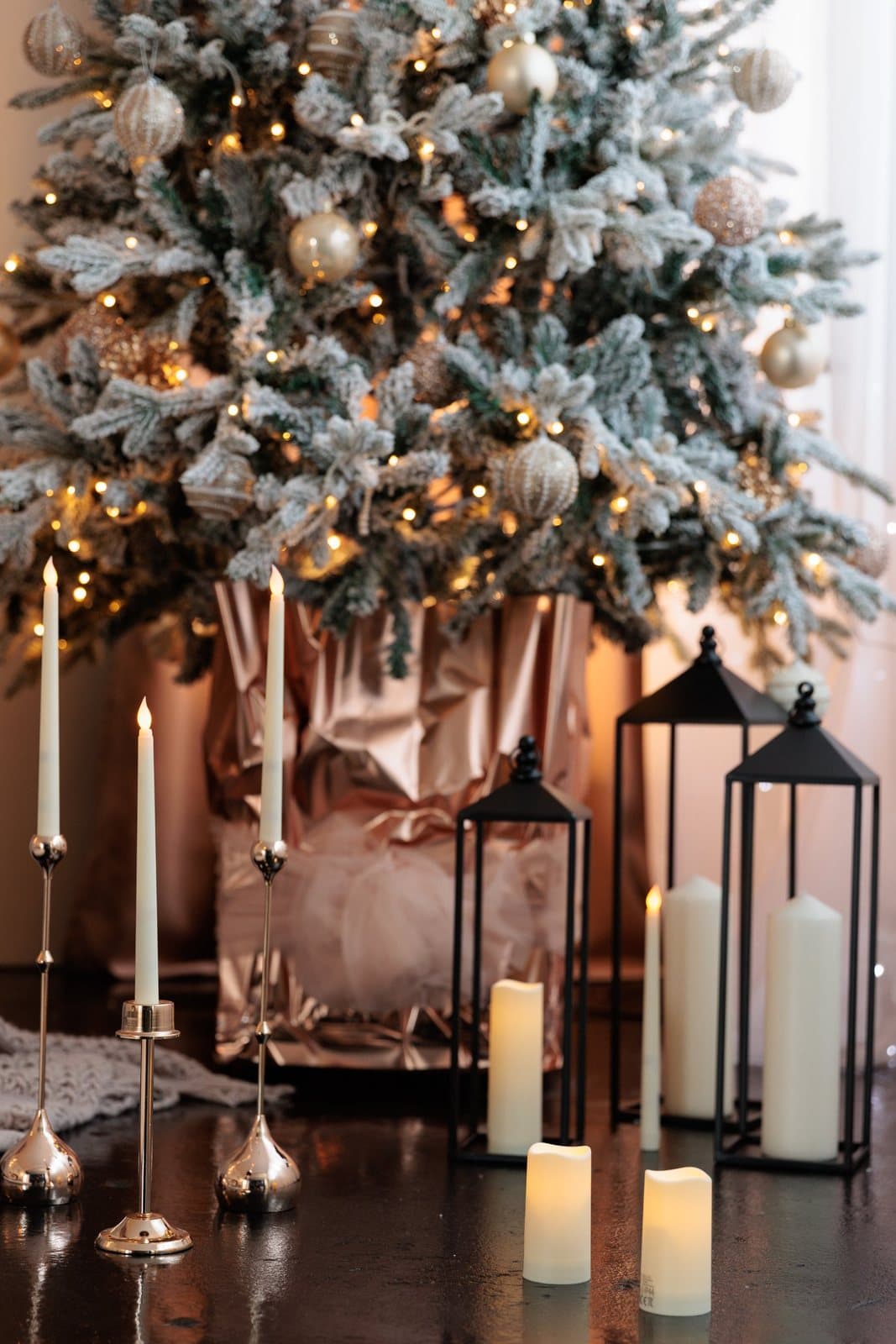 Kerzen und Laternen vor dem geschmückten Weihnachtsbaum